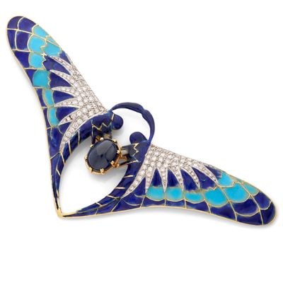 un gros plan sur une broche bleue et blanche sertie de diamants