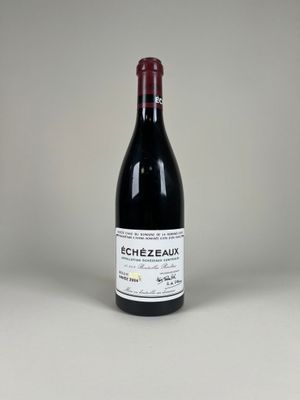 une image représentant une bouteille de vin rouge posée sur une surface blanche