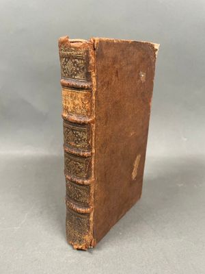 un vieux livre posé sur une table à côté d'un fond gris