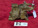 un petit éléphant en bronze avec une étiquette sur le dos
