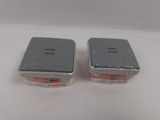 two salt and pepper shakers sitting on a white surface