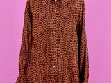 une chemise à imprimé léopard marron et noir sur un mannequin de boutique