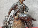 statue en bronze représentant un homme assis sur une souche d'arbre en compagnie d'un chien