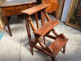 un tabouret en bois posé devant un tableau