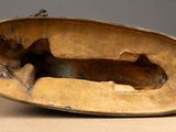 a bronze sculpture of a dog inside of a bowl