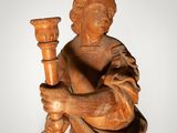 an old wooden statue of a man holding a torch in his hand