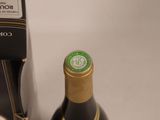 a bottle of wine sitting next to a bottle opener