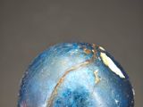 a close up of a hand holding a blue stone