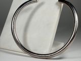 an image of a close up of a silver bracelet on a marble stand