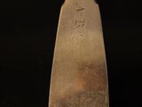 a close up of a silver spoon on a black surface