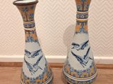 une paire de vases bleus et blancs ornés d'oiseaux, posés sur un plancher en bois
