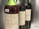 several bottles of wine are lined up on a glass shelf