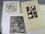 trois livres posés sur une table, sur lesquels figurent des dessins représentant des personnes et des animaux
