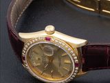 a gold watch with diamonds on it sitting on a black surface