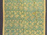 un vieux tissu vert et jaune orné de fleurs jaunes