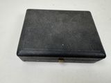 an old black leather case with a key on a white surface