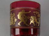 a red glass with a gold design on it