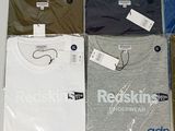 six t - shirts in a plastic bag with tags on them
