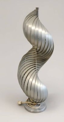 a silver spiral lamp that is on a table