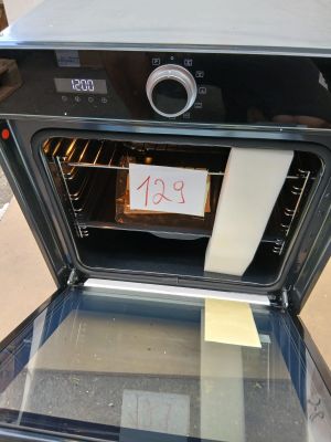 un four noir sur la porte duquel est accrochée une pancarte