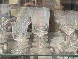 many glasses of champagne on display in a glass case