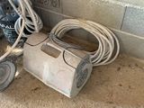a vacuum that is sitting on the floor next to a wall