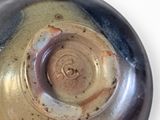 a close up of a brown and black bowl on a white surface