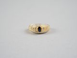 une bague en or jaune sertie d'une pierre bleue entourée de diamants