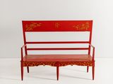 une image représentant un banc rouge orné d'un motif rouge et or