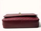 burgundy leather clutch bag with gold hardware and flap closure