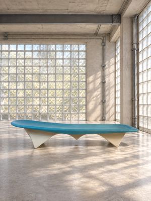un banc bleu et blanc dans une pièce dotée de grandes fenêtres