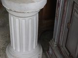 a statue of a woman sitting on a pedestal in a room