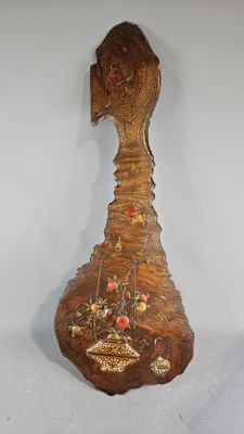 a wooden sculpture of a bird with flowers on it ' s head
