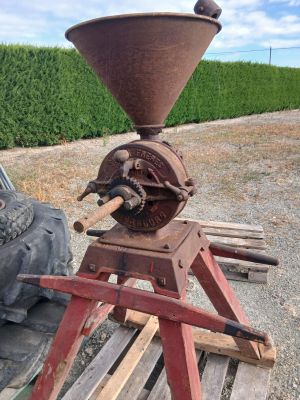 un vieux moulin à café posé sur un socle en bois