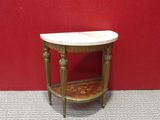 a small table with a marble top in front of a red wall