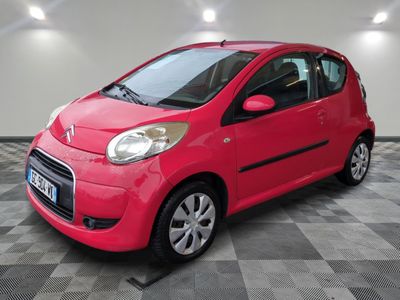 la petite voiture rouge est garée sur un sol en damier