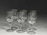 plusieurs verres à vin vides sont alignés sur une surface blanche