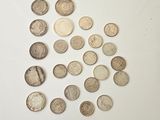 a pile of silver coins sitting on top of a white surface