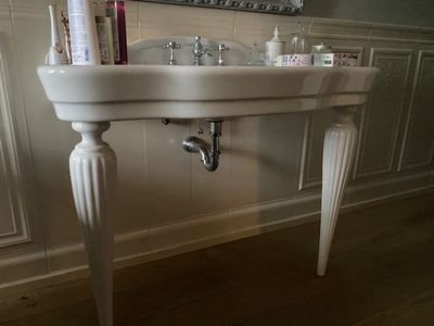 un lavabo blanc dans une salle de bains, avec un miroir au-dessus