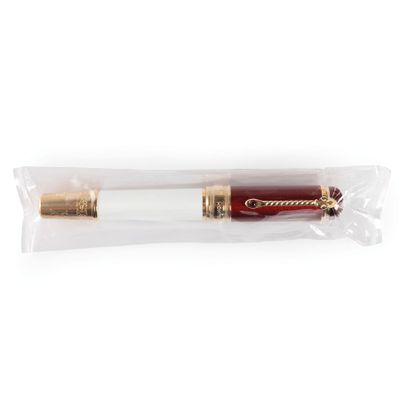 un stylo plume rouge et doré posé sur un sac transparent