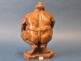 an image of a statue of a man sitting on top of a wooden base