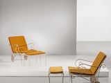 une chaise orange et un pouf dans une pièce blanche aux murs blancs