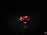 a close up of a red diamond on a black surface