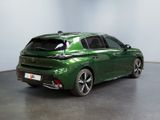 the rear view of a green car parked in a room