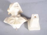 une statue représentant une femme et un bougeoir posés sur une table