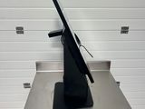 a metal table with a monitor on it in front of a garage door