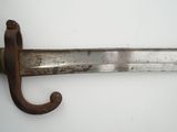 a close up of a sword on a white surface