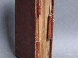 a small book with a brown cover on a gray surface