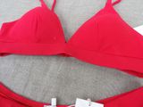 a close up of a red bikini top with a tag on it