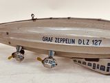 a silver and yellow model of an airplane on a white surface
